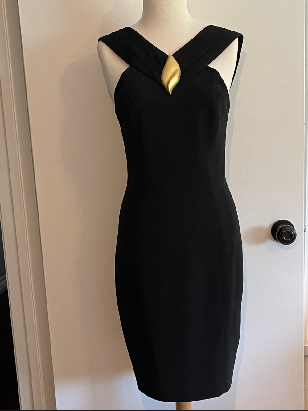 Black cocktail dress with gold pendant accent